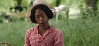 Lady Russell sitting outdoors with a sly expression.