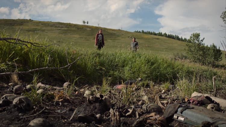 Joel and Ellie stare at a mass grave