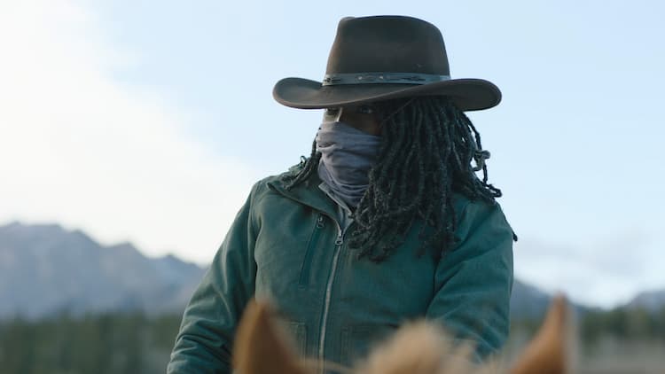 Maria, masked, riding a horse