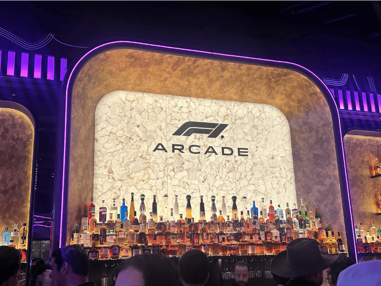 F1 bar at F1 Arcade. The F1 Arcade logo is backlit behind bottles of alcohol.