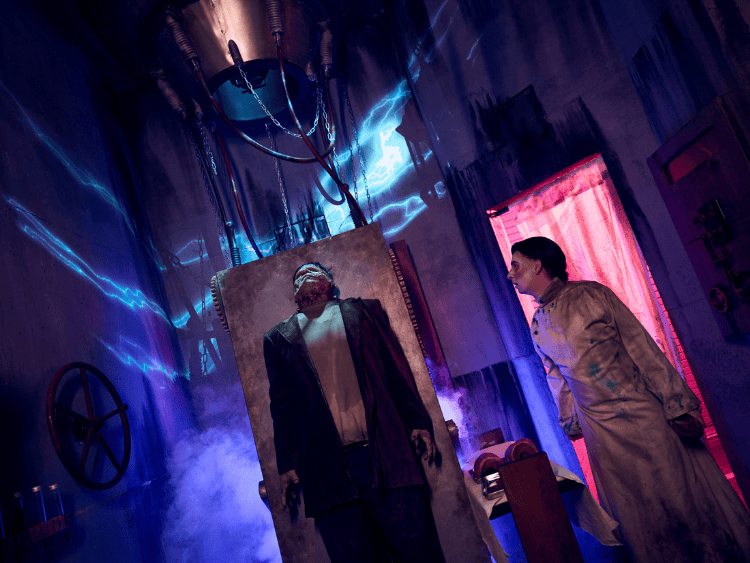 A scene of Dr. Frankenstein bringing his monster to life in the Universal Monsters haunted house. The monster is laying on a table before Dr. Frankenstein pulls down the lever for electricity. 