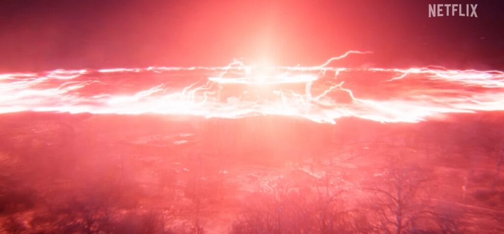 A dramatic scene from Stranger Things 5 shows a massive red‑and‑blue energy explosion erupting from the Hawkins Lab located in the Upside Down, with chaotic light and debris radiating outward.