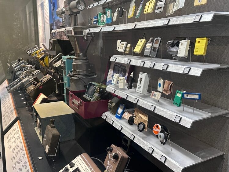 A wall of nuclear testing artifacts. Among the actual artifacts are a Pip-Boy from Fallout.