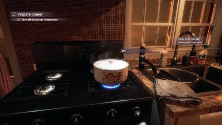 It is a small kitchen indoors. There is a pot on the boiler.