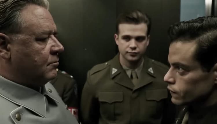 Goring and Kelly are face-to-face. Howie Triest is standing between them. Goring is looking down at Kelly, who is looking up at him. Another officer is standing to Goring's left.