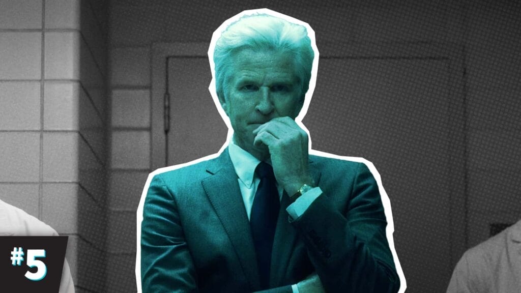 A stern-faced Dr. Brenner wearing a lab coat, standing in a shadowy lab room, lit by harsh fluorescent lights.