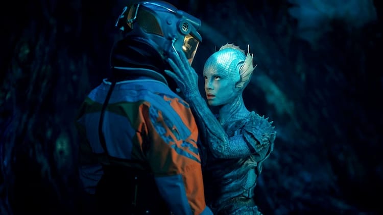 Barclay, left, is wearing futuristic diving gear. Salt, right, is touching his helmet with both hands.
