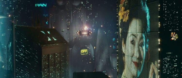 A flying car surrounded by tall buildings and a holographic advertisement. It is nighttime.