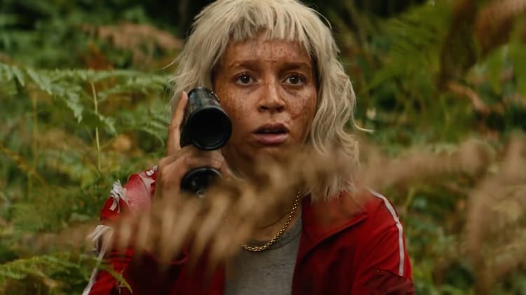 Jimmy Ink is looking forward. She has binoculars in her right hand. She is crouched behind plants.