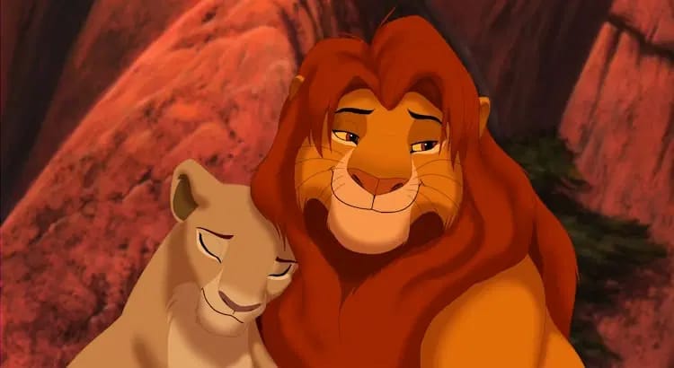 Nala, left, is resting her head on Simba’s mane, right. They are standing on Pride Rock. Nala’s eyes are closed.